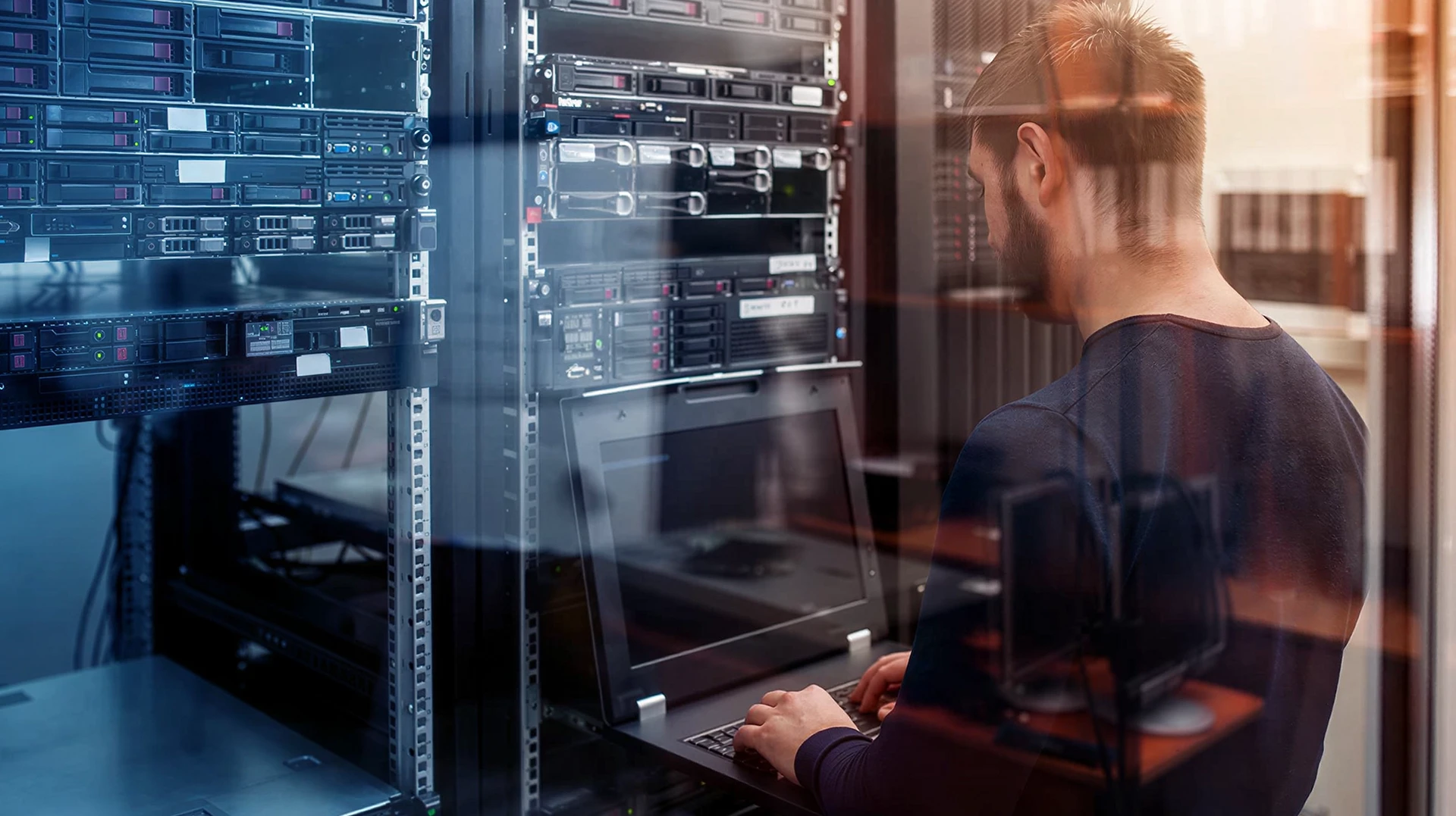 Salle de serveurs avec technicien en chemise blanche travaillant sur équipements informatiques